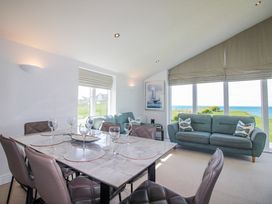 A dining room with a table set for dinner at 7 Ocean's Edge in Thurlestone