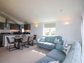 A living room with a dining area and kitchen at 7 Ocean's Edge Thurlestone
