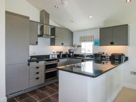 A kitchen with appliances and cabinets at 7 Ocean's Edge in Thurlestone