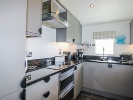 A kitchen with cabinets and appliances at 7 Ocean's Edge Thurlestone