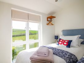 A bedroom with a bed and window at 7 Ocean's Edge Thurlestone