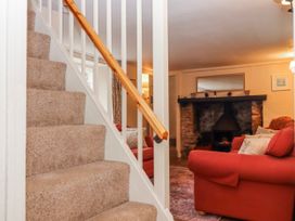 A living room with a fireplace and sofa at Yew Tree Cottage Stoke Fleming