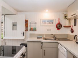 A kitchen with a sink and oven at Yew Tree Cottage in Stoke Fleming