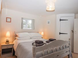 A bedroom with a bed and lamps at Yew Tree Cottage Stoke Fleming