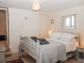 A bedroom with a bed and nightstand at Yew Tree Cottage in Stoke Fleming