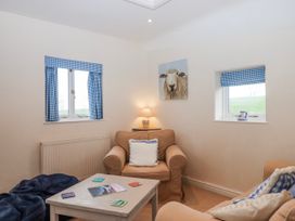 A living room with a sofa and table at Yew Tree Cottage Stoke Fleming