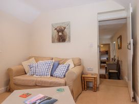 A living room with a sofa and painting at Yew Tree Cottage in Stoke Fleming