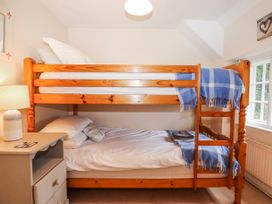 A bedroom with a bunk bed and a lamp at Yew Tree Cottage Stoke Fleming