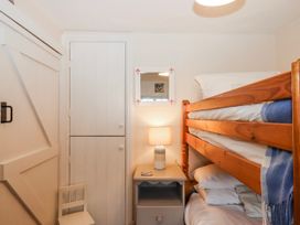 A bedroom with a bunk bed and a lamp at Yew Tree Cottage Stoke Fleming