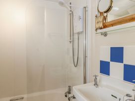 A bathroom with a shower and washbasin at Yew Tree Cottage in Stoke Fleming