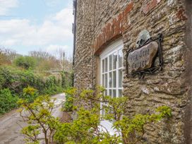 An outdoor view of Yew Tree Cottage with a sign and window in Stoke Fleming