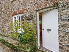 An entryway with a stone wall and a white door at Yew Tree Cottage in Stoke Fleming