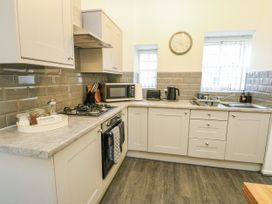 A kitchen with a gas stove and microwave at 2 Mountain View Talwrn near Llangefni