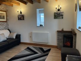 A living room with a sofa and a rug at Ysgubor Ddegwm Bach in Llanddona near Beaumaris