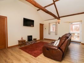 A living room with a sofa, rug, and television at Crabtree Cottage in Suffield near Scalby