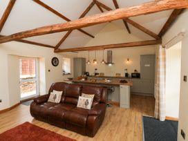 A living room with a sofa and kitchen area at Crabtree Cottage in Suffield near Scalby