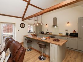 A kitchen with an island and bar stools at Crabtree Cottage in Suffield near Scalby