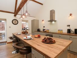 A kitchen with an island and bar stools at Crabtree Cottage in Suffield near Scalby