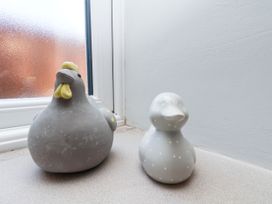 A chicken and a duck figurine near a window at Crabtree Cottage Suffield near Scalby