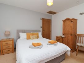 A bedroom with a bed and wooden furniture at Crabtree Cottage in Suffield near Scalby