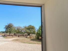 A view of a fence and trees from a doorway at Crabtree Cottage Suffield near Scalby