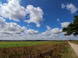 A field with clouds and a road at Crabtree Cottage in Suffield near Scalby