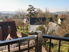 A view from a balcony showing houses and trees at Cambrie in Tenby
