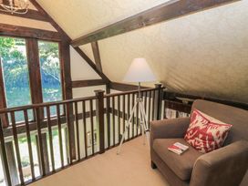 A loft with a lamp and armchair at The Barn at Frog Pond Farm Antsy near Tisbury