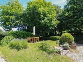 A garden with a table and chairs under an umbrella at The Barn at Frog Pond Farm Antsy near Tisbury