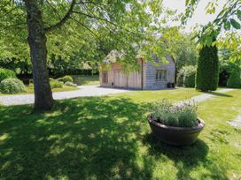 A building surrounded by grass and trees at The Barn at Frog Pond Farm in Antsy near Tisbury