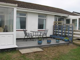 A patio with a table and chairs at Hafod-y-Gors in Fairbourne