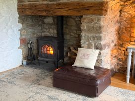 A living room with a fireplace and a seating area at Stable Cottage Newport, Pembrokeshire
