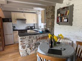A kitchen with a dining table and flowers at Stable Cottage in Newport, Pembrokeshire