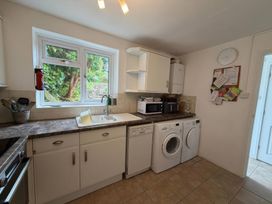 A kitchen with a sink, washing machine, and dishwasher at Derlwyn, Newport, Pembrokeshire