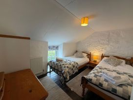 A bedroom with two single beds and a window at Derlwyn in Newport, Pembrokeshire