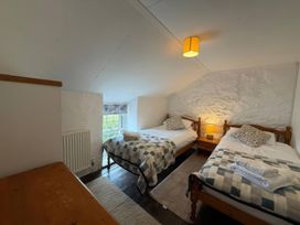A bedroom with two beds and a window at Derlwyn in Newport, Pembrokeshire