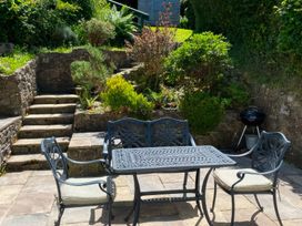 A garden with a table and chairs and steps at Derlwyn Newport, Pembrokeshire