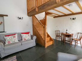 A living room with a sofa and dining area at West End Cottage in Newport, Pembrokeshire