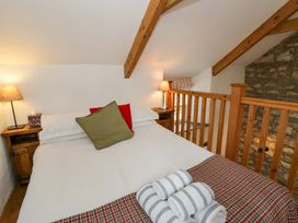 A bedroom with a bed and nightstand at West End Cottage Newport, Pembrokeshire