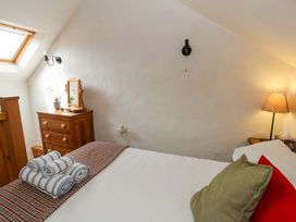 A bedroom with a bed and a lamp at West End Cottage Newport, Pembrokeshire