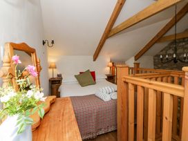 A bedroom with bed, wooden furniture and towels at West End Cottage Newport, Pembrokeshire