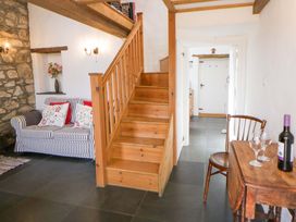 A living room with a couch and a staircase at West End Cottage in Newport, Pembrokeshire