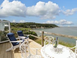 An outdoor seating area with chairs and a table at Clifftop Carriage, Aberporth, Ceredigion