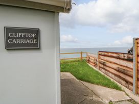 A sign reading Clifftop Carriage next to a view of the ocean in Aberporth, Ceredigion