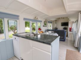 A kitchen with a sink and sofa at Clifftop Carriage in Aberporth, Ceredigion