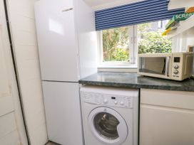 A laundry room with a fridge and washing machine at Clifftop Carriage Aberporth, Ceredigion