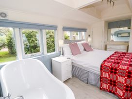 A bedroom with a bed and bathtub at Clifftop Carriage in Aberporth, Ceredigion