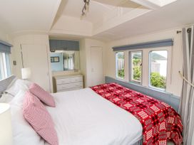 A bedroom with a bed and dresser at Clifftop Carriage in Aberporth, Ceredigion