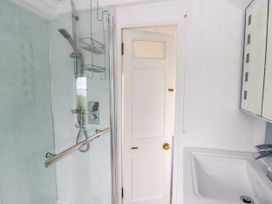 A bathroom with a shower and sink at Clifftop Carriage in Aberporth, Ceredigion