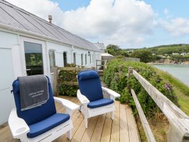 An outdoor area with chairs on a deck at Clifftop Carriage in Aberporth